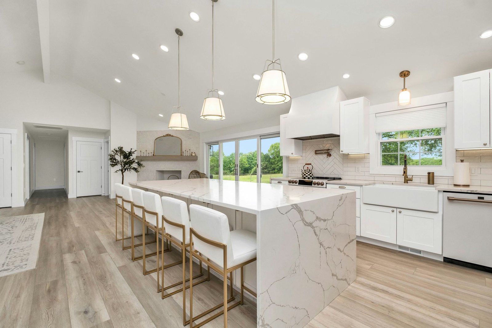 Large kitchen with marble island and white cabinetry
