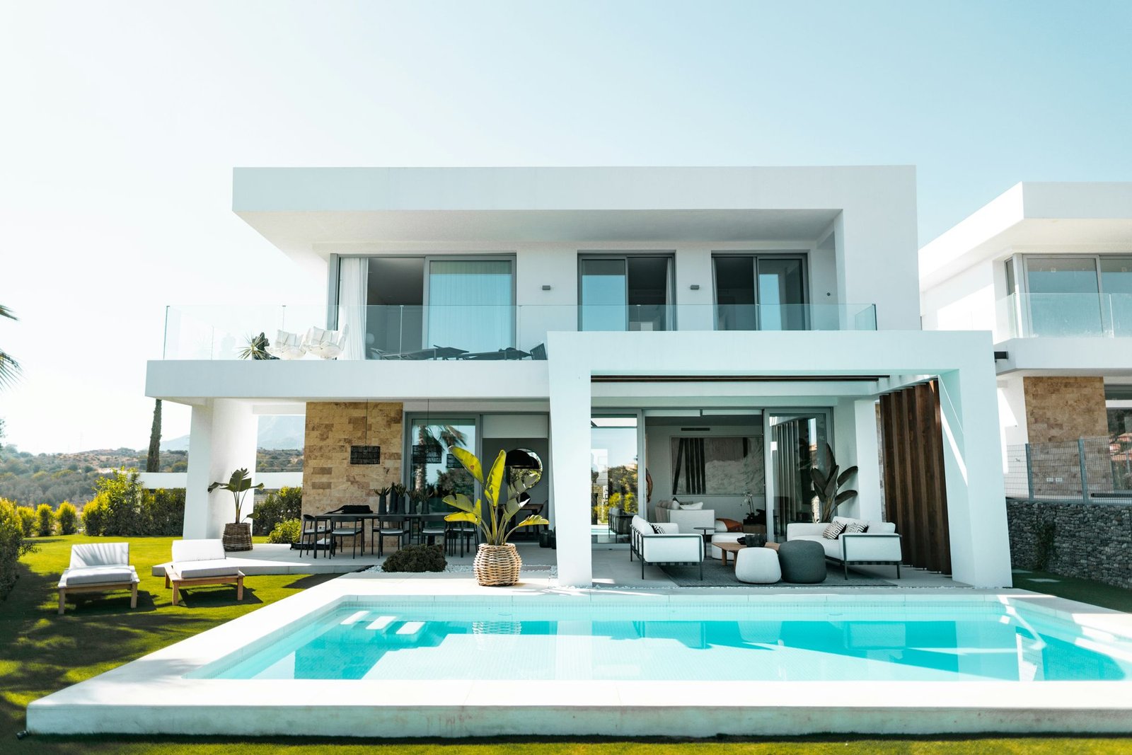White contemporary home with pool and outdoor lounge